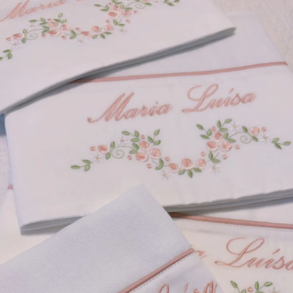 Fraldas com o nome Maria Luísa bordado em rosa com flores